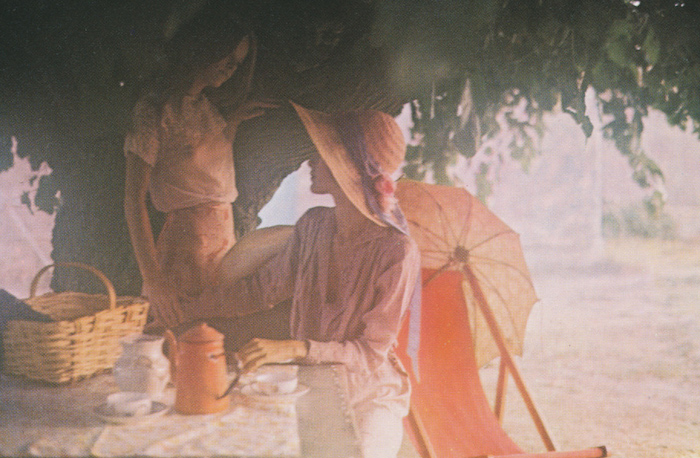 a man standing next to a woman and orange umbrella