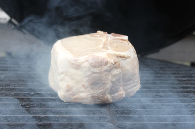 raw meat being cooked on an open bbq grill