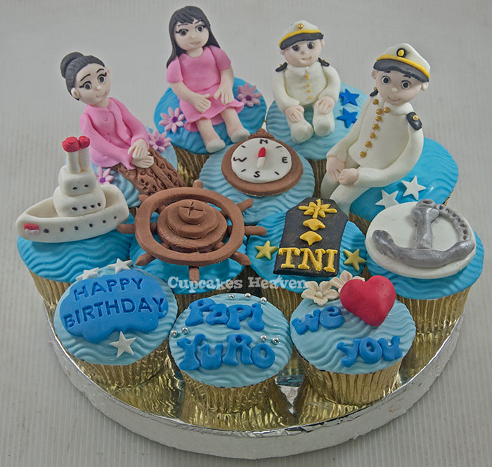 a cupcake with blue frosting, with small figures