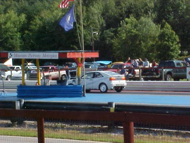 cars at a gas station with people around them