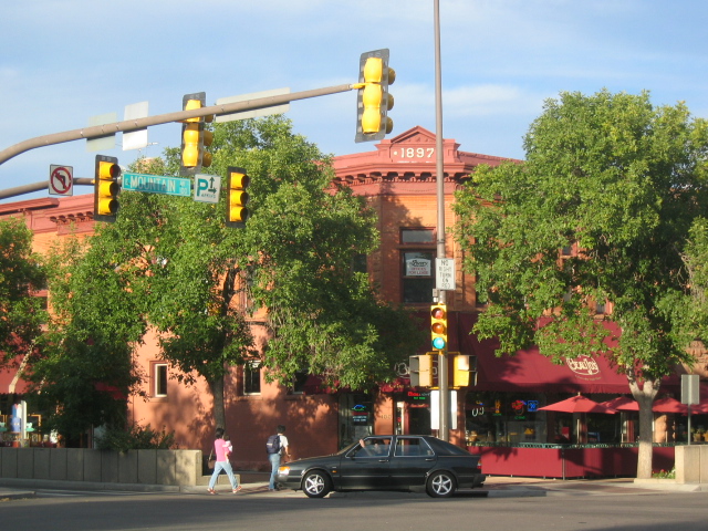 traffic and pedestrian lights along a busy intersection
