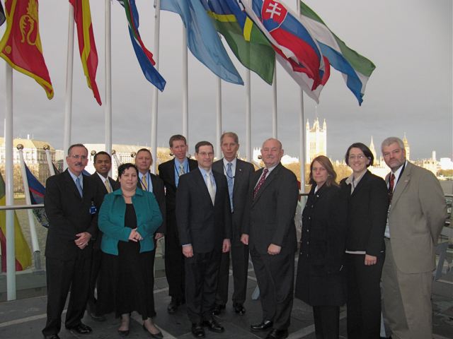 a group of people standing in front of many flags