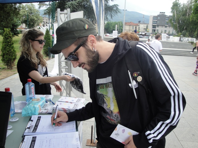 a young man signing through some documents while standing near other people