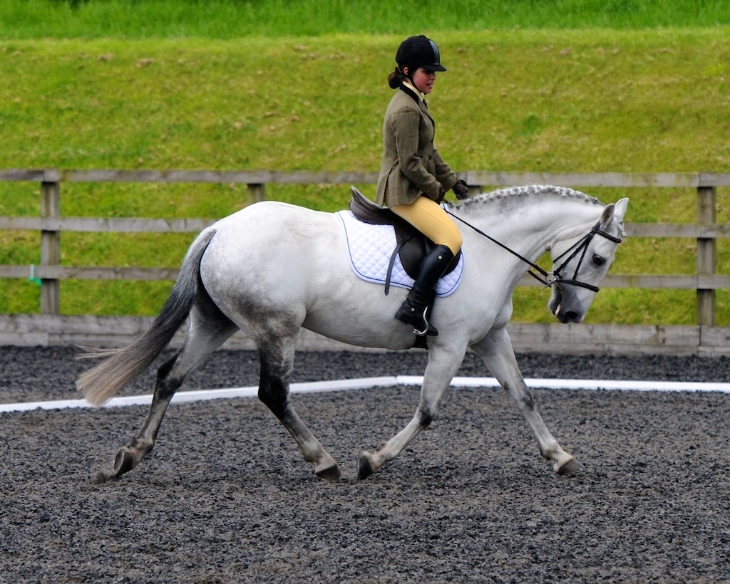 a person riding a horse while wearing a helmet