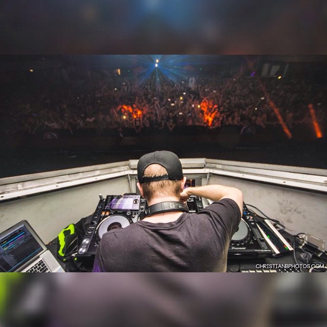 a dj in front of a large crowd watching his music