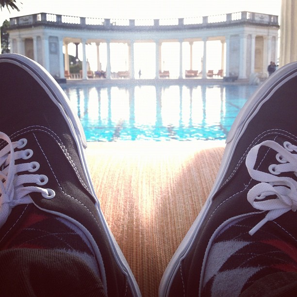 a pair of shoes is sitting on the floor by a pool