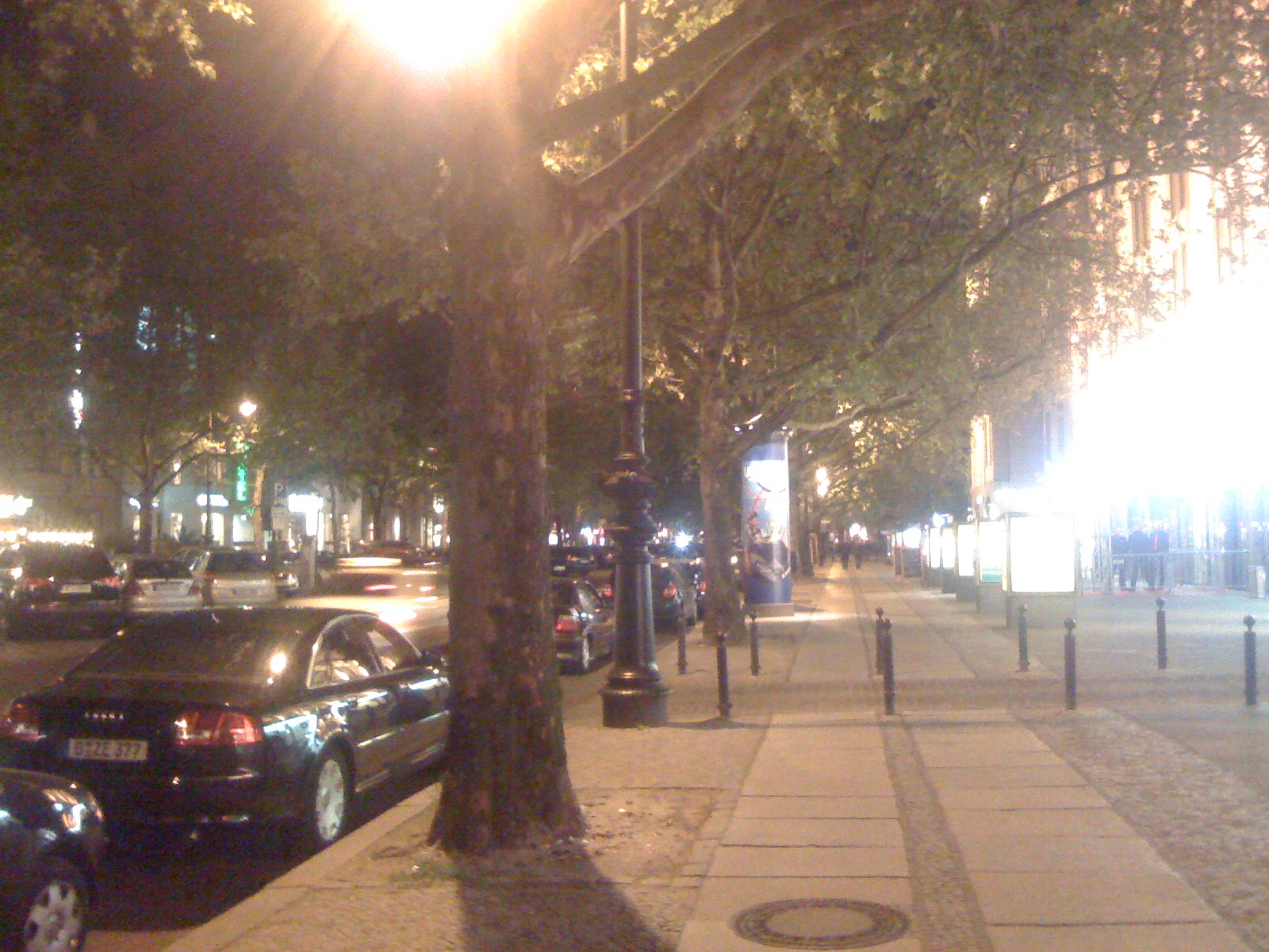 cars are driving down a city street next to the sidewalk