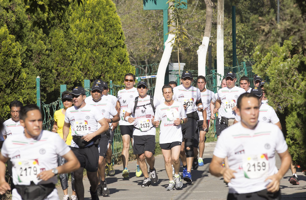 a group of men racing down a sidewalk in a marathon