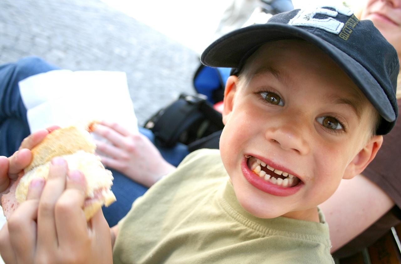 a close up of a child holding a sandwich