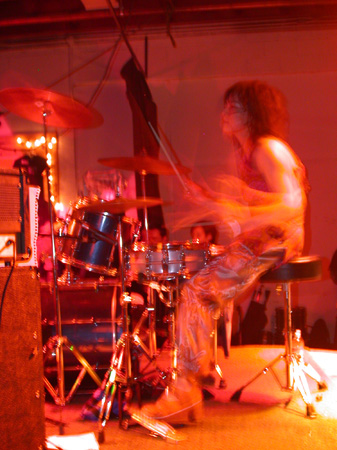 drummer playing a guitar in a room with several other instruments