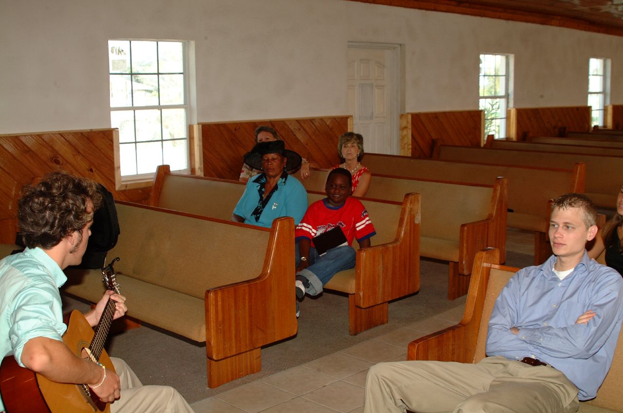 s sit in pews playing music while two women watch
