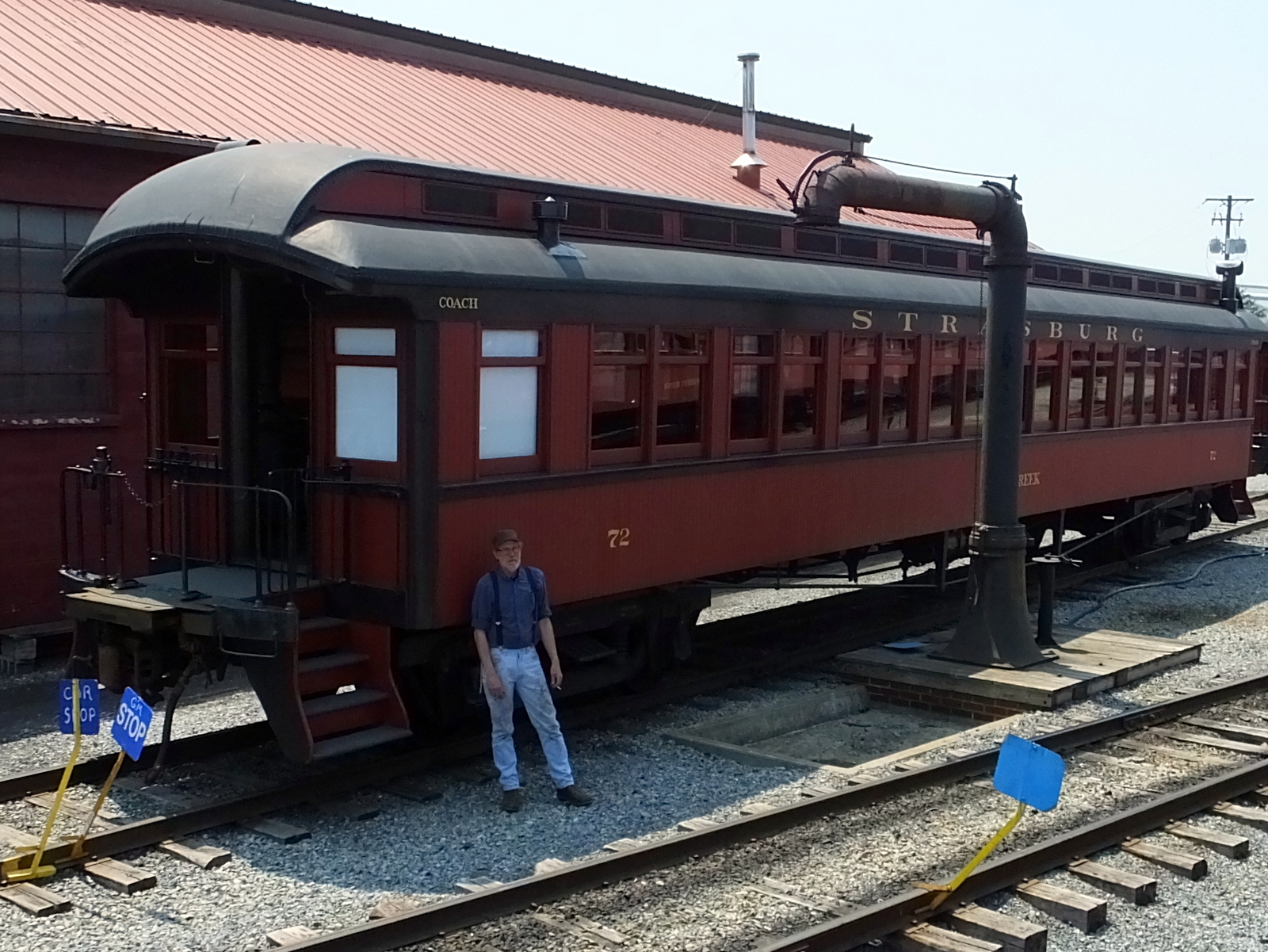 a man standing by a train on a track