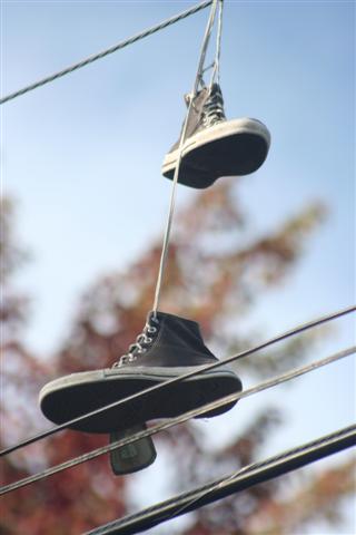 a pair of tennis shoes hanging upside down on power lines