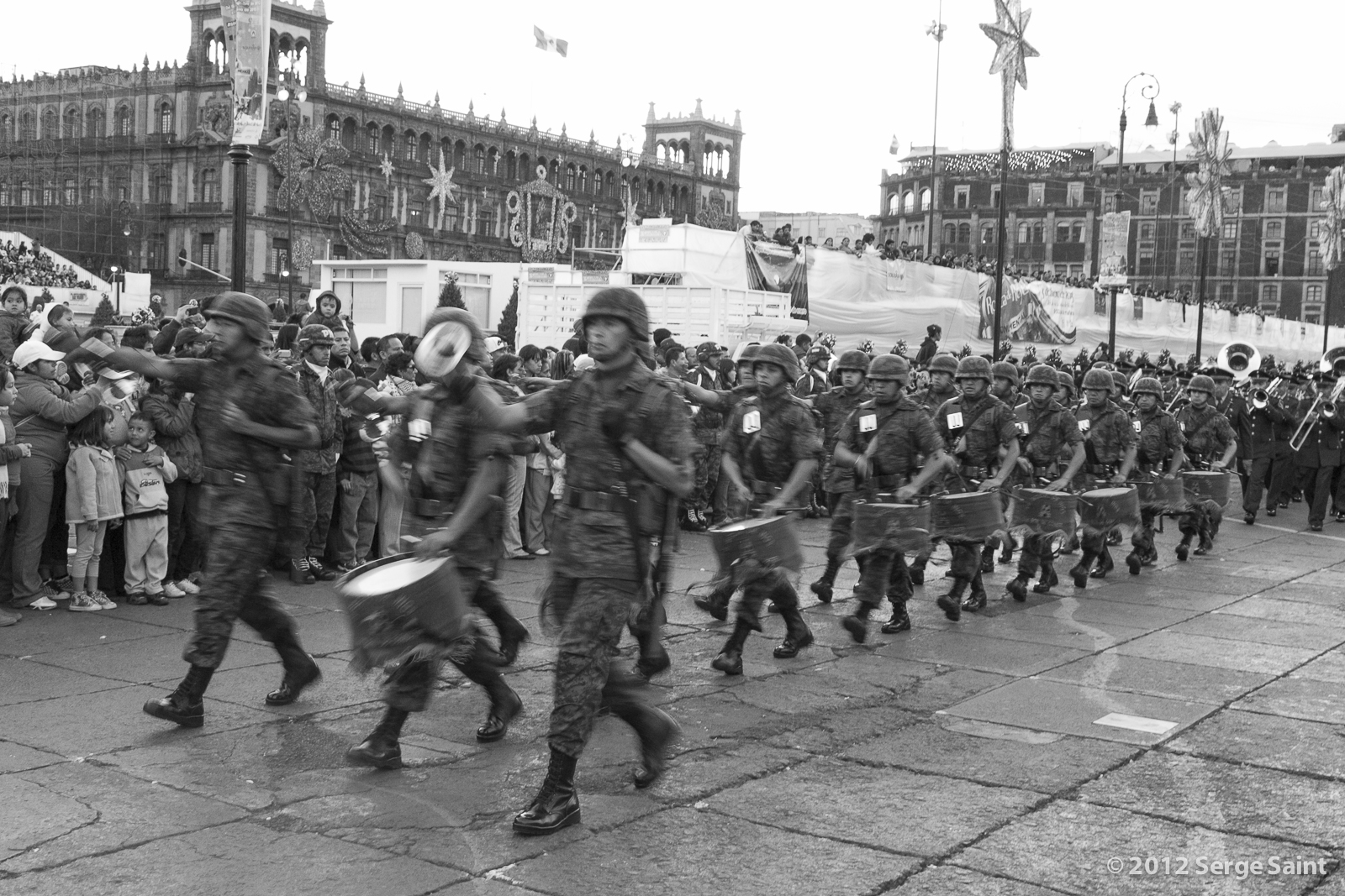 many military officers are walking in a line in the streets