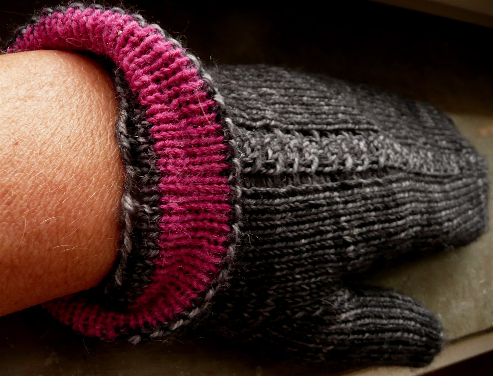 someone holding their arm with a hand knitted wrist warmer