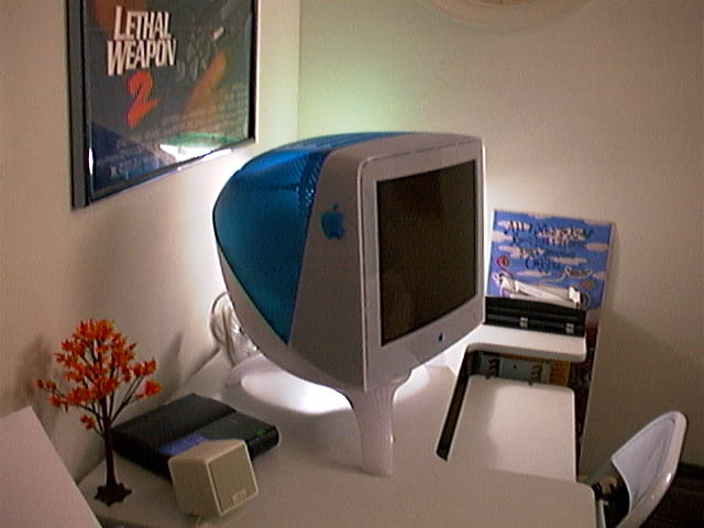 a computer is sitting on a desk with a vase
