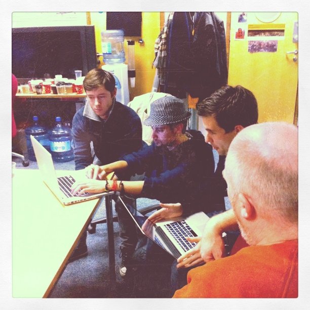 several young men working on a laptop together