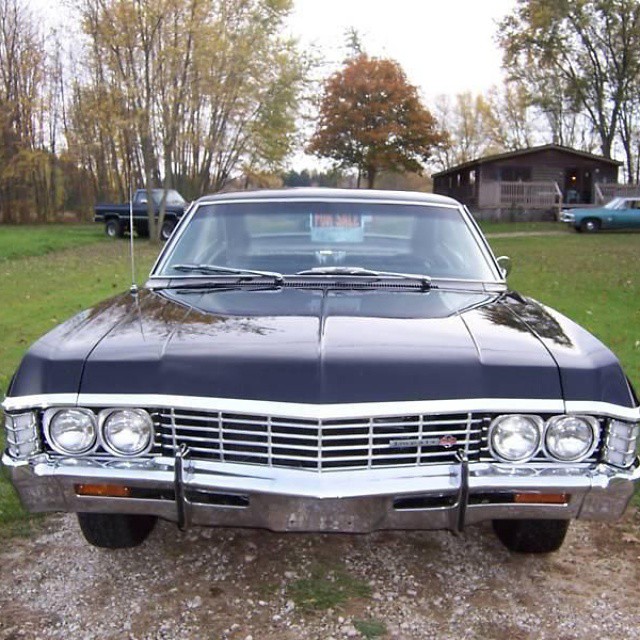 a black chevrolet belved sits on a gravel driveway