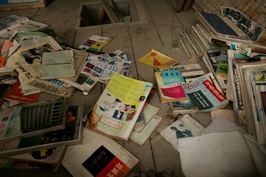 a pile of newspaper and magazines laying on a floor