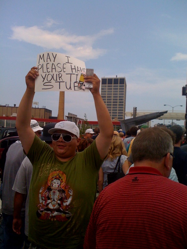 a protestor holds up his sign in the middle of a group