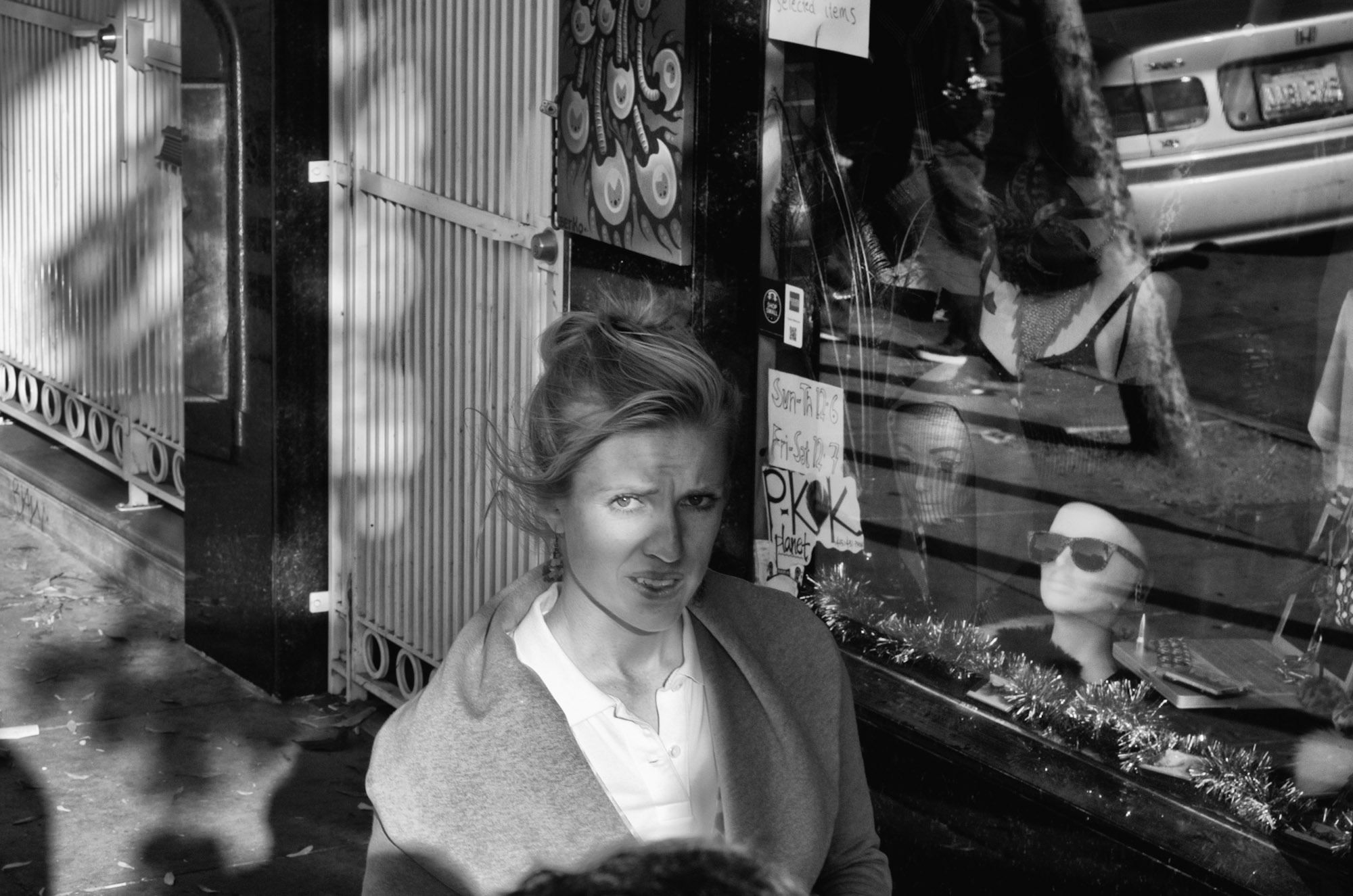 a woman standing outside of a store window with a camera