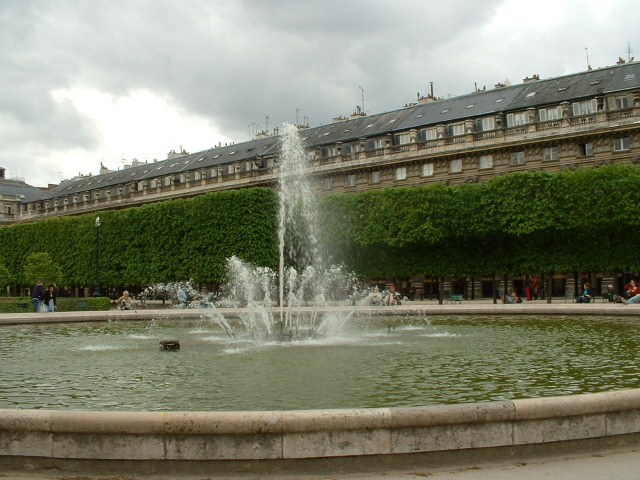 a fountain is in front of a large building