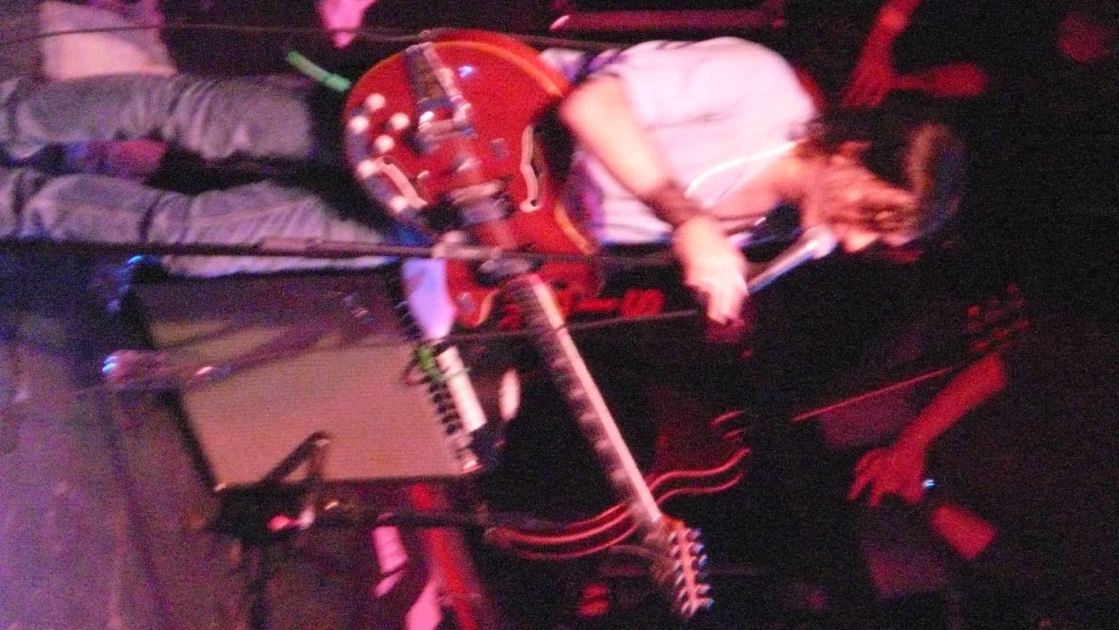 a young man in jeans is singing and playing guitar