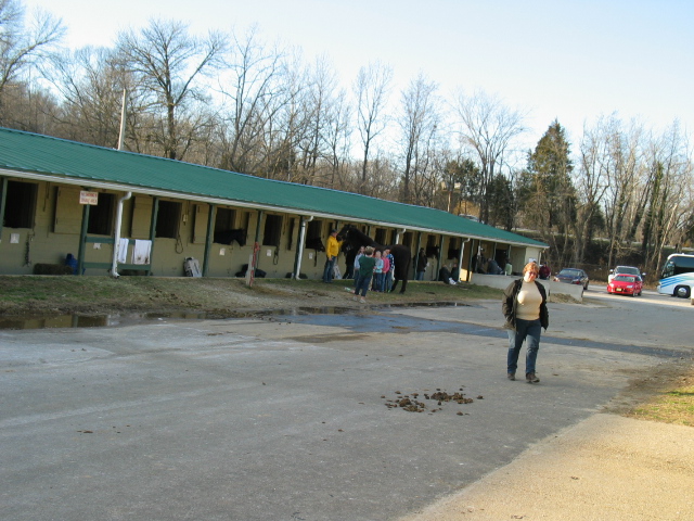 people walking by buildings with green roof and parking lot