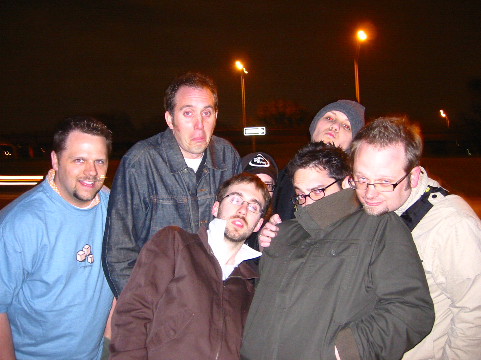 a group of men standing on a street corner together