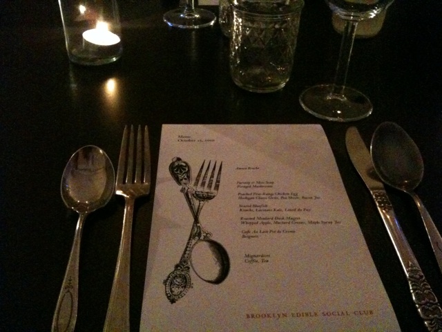 a restaurant table with glasses, silverware and menu