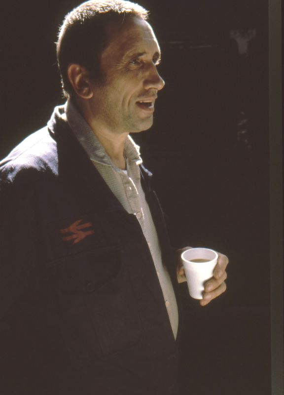 a man holding a cup and talking to someone