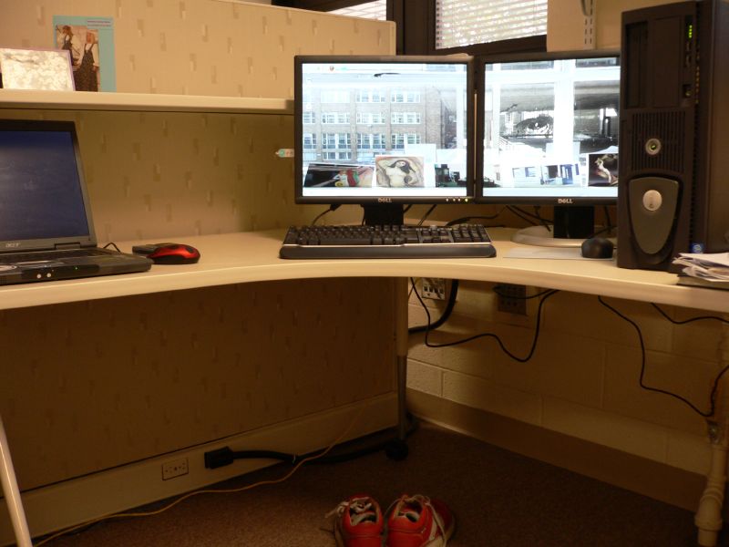 computer set up in corner with other computers on the table