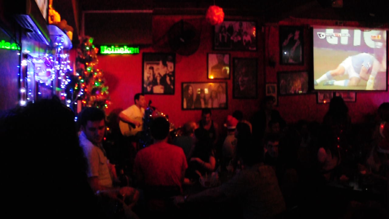 a view inside of a restaurant with red walls and dark room filled with people