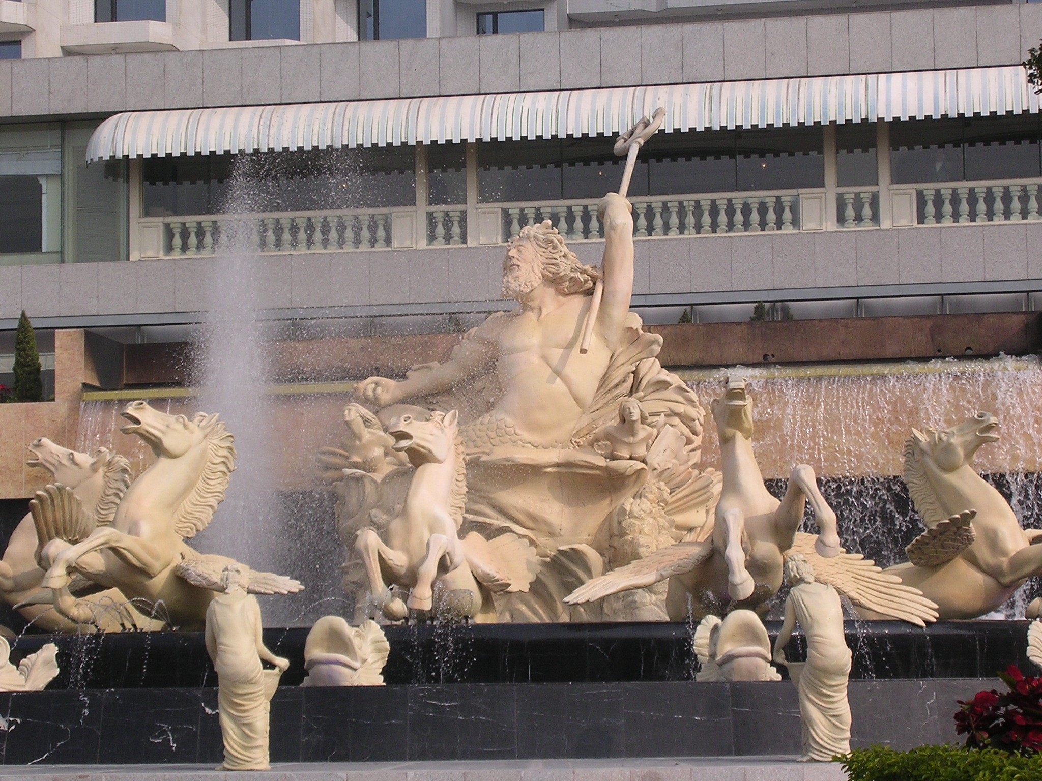 a fountain with statues of women and birds in it