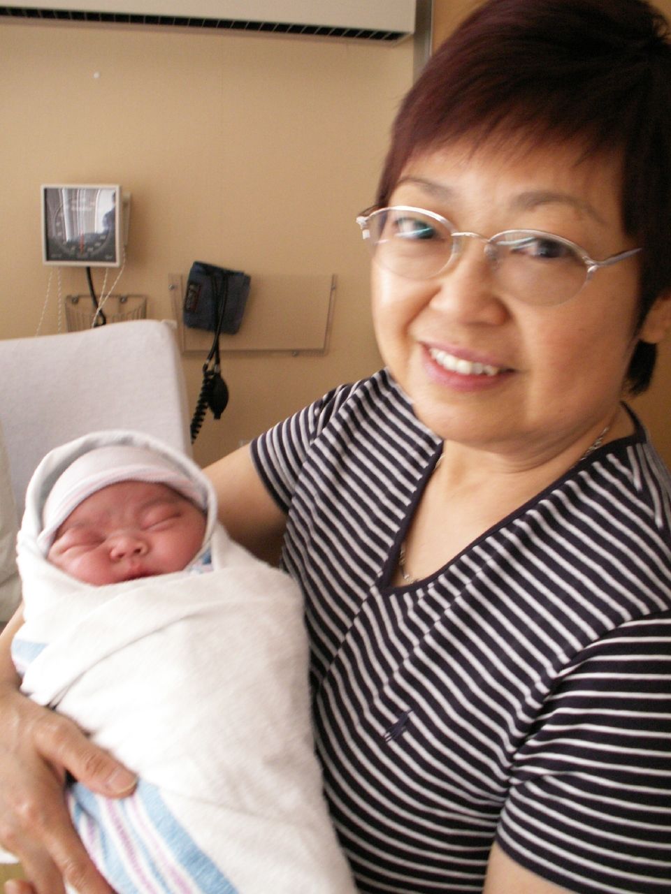 a woman smiling while holding her newborn child