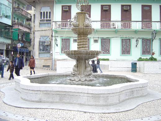 a fountain is in the middle of a courtyard