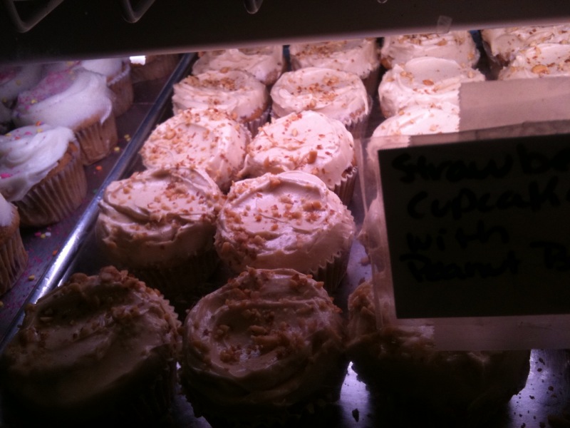 large assortment of frosted cupcakes at the bakery