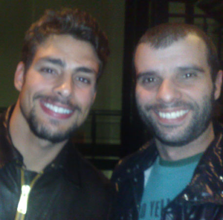 two men are posing for a picture one has a large smile on his face and the other has a beard