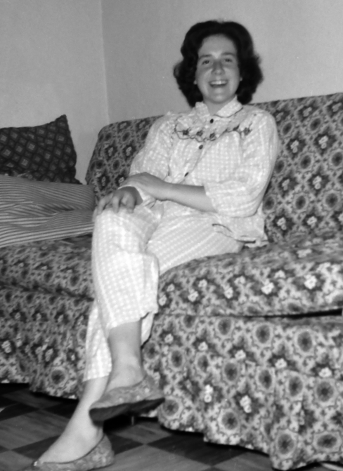 an old po of a smiling woman sitting on a couch