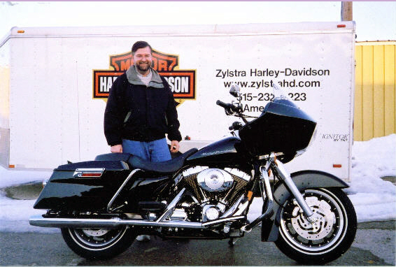 man standing next to a black motorcycle parked outside