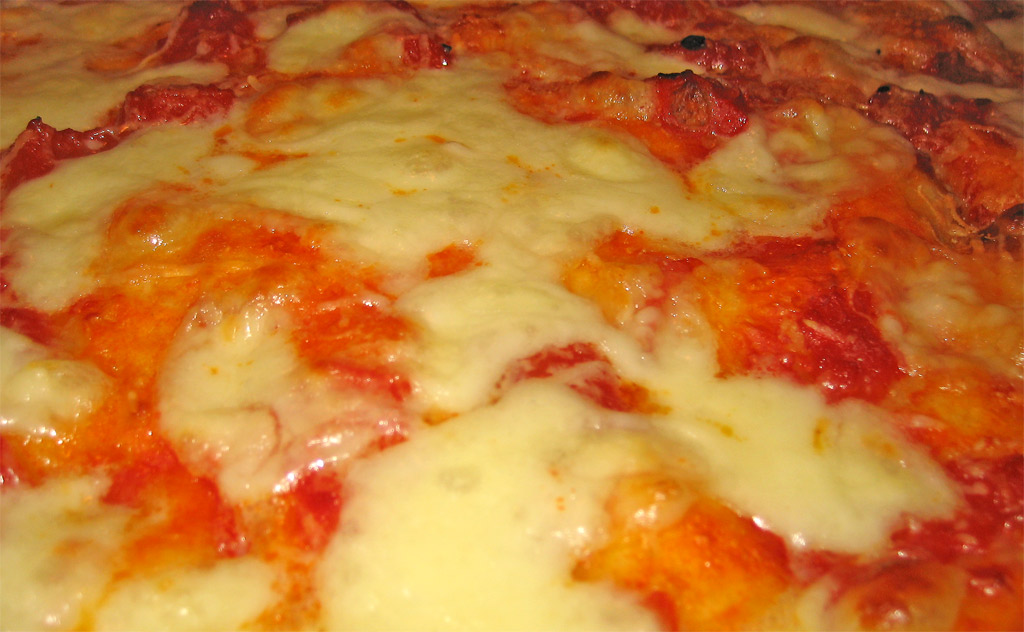 a very close up of cheese pizza in a dish