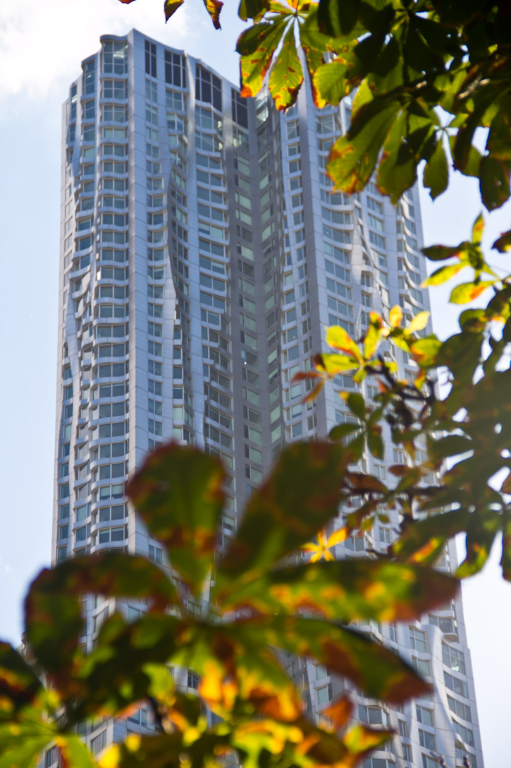 a very tall high rise building sitting next to some trees