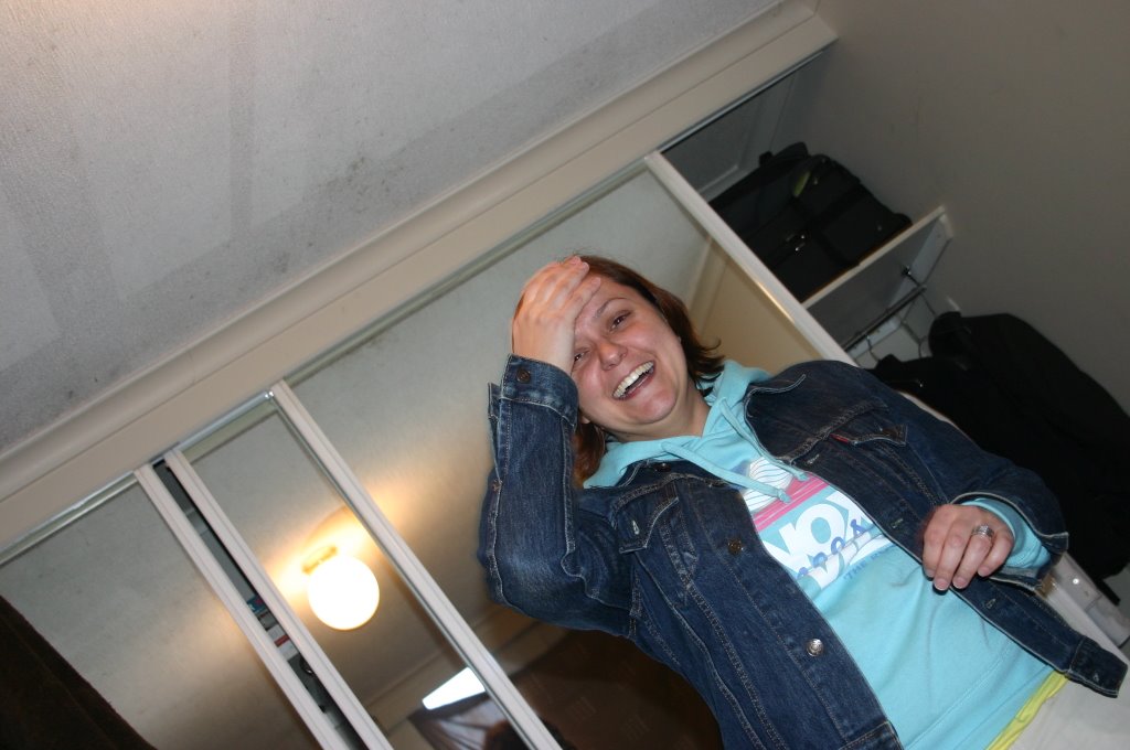 a smiling woman in a room is holding her jacket up