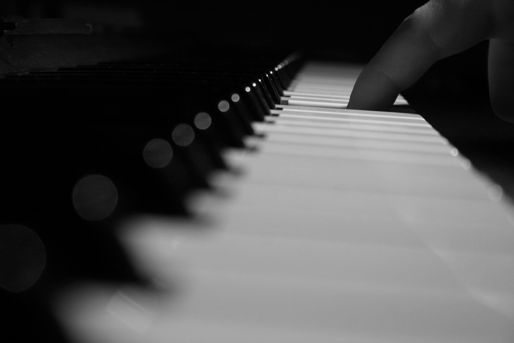 the finger is resting on the piano