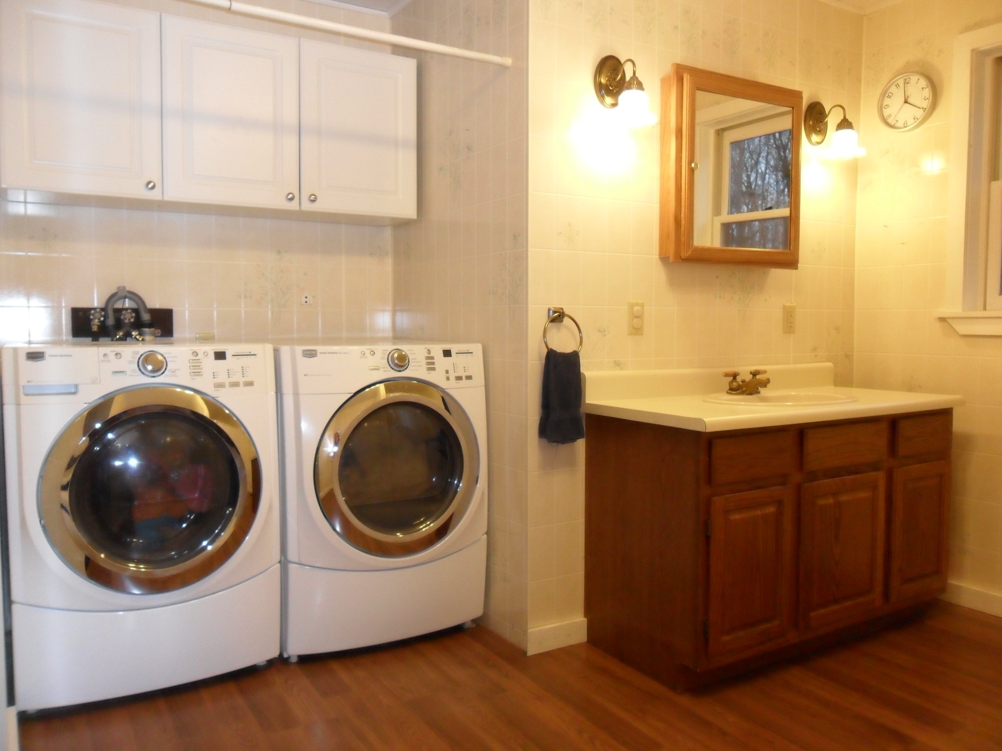 an all white bathroom with washers and dryer