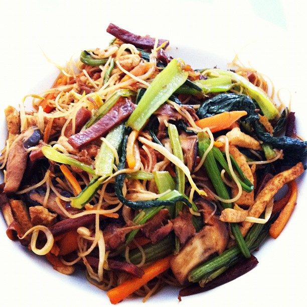 a white bowl filled with pasta, vegetables and sauce