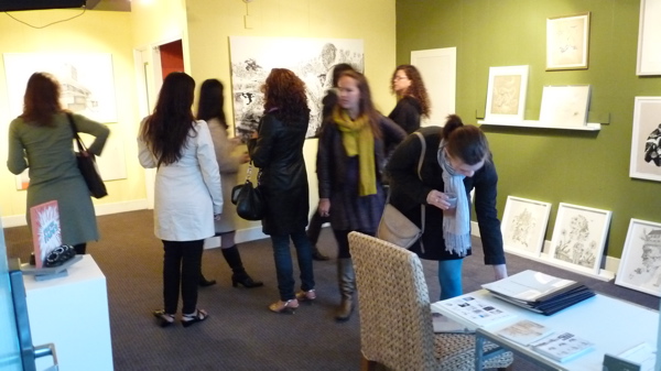 many young women standing in a living area of an art gallery
