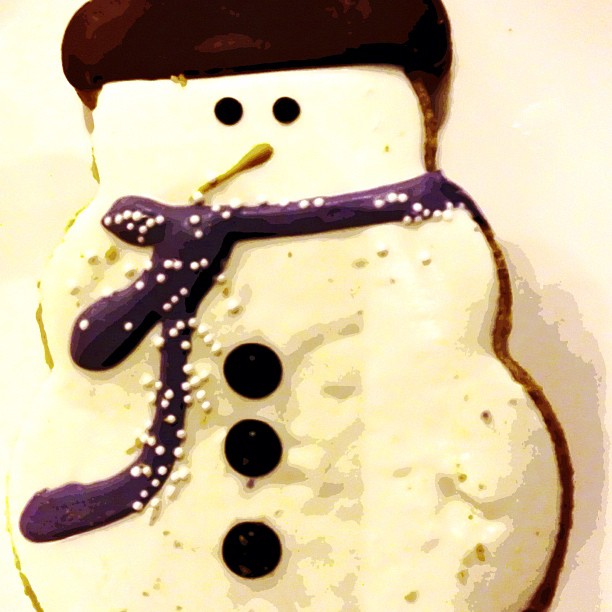 a snow man with purple and black decorations on it's face