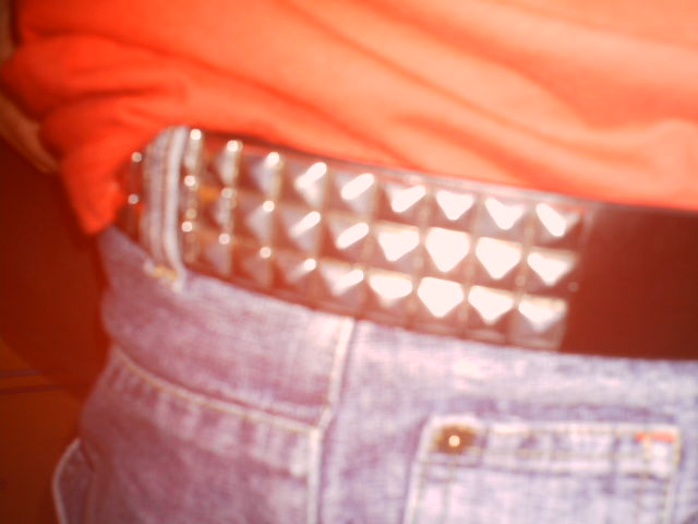 a pair of jeans with studded metal buckles and a man in an orange shirt