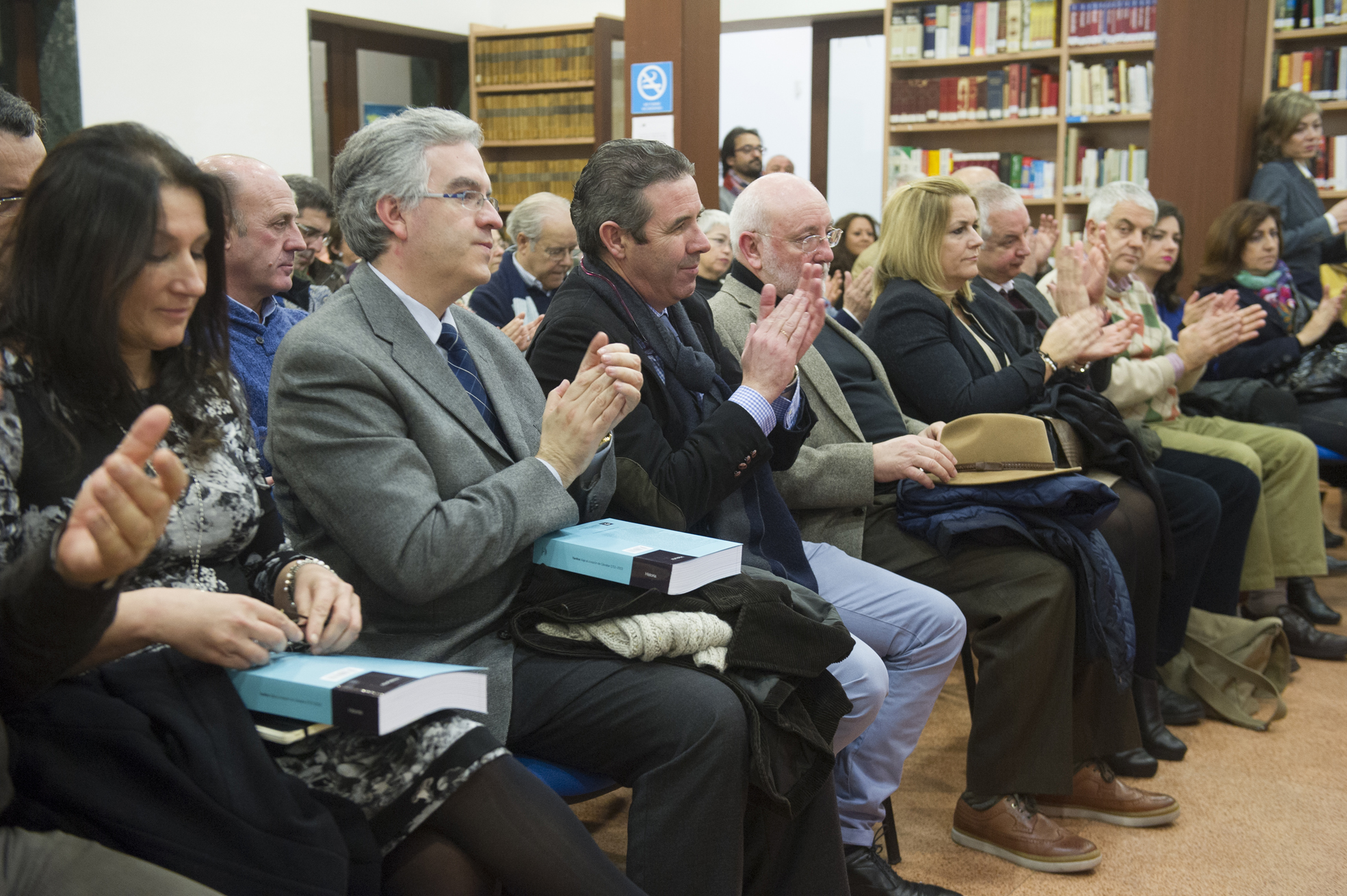 a group of people sitting in a liry clapping